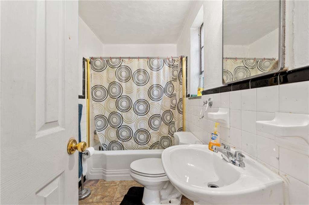 1627-1629 Laketon Road Pittsburgh, PA 15221 - Photo 26 of 26 a bathroom with a sink and mirror with toilet
