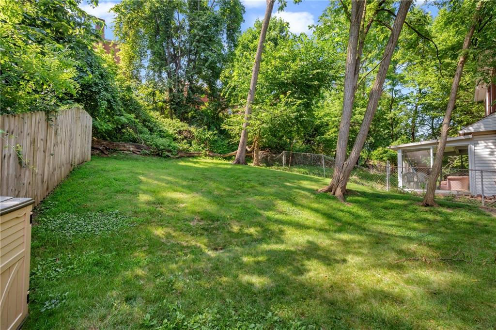 1627-1629 Laketon Road Pittsburgh, PA 15221 - Photo 6 of 26 a backyard of a house with lots of plants and large tree
