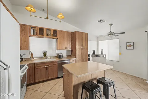 a kitchen with a sink a stove cabinets and dining table