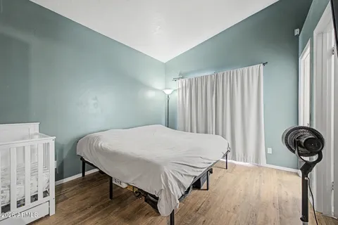a bedroom with a bed and wooden floor