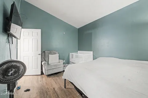 a bedroom with a bed a couch and flat screen tv