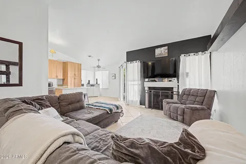 a bedroom with a bed a couch and a flat screen tv