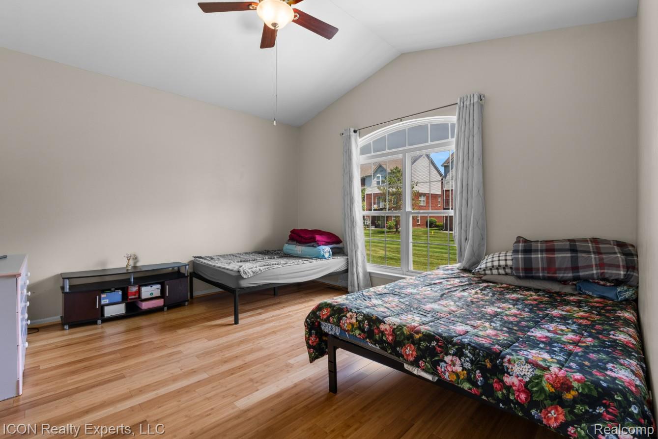 531 Cherry Grove Road Canton, MI 48188 - Photo 20 of 30 Room featuring a vaulted ceiling with a ceiling fan, wood-finish flooring, and a large arched window