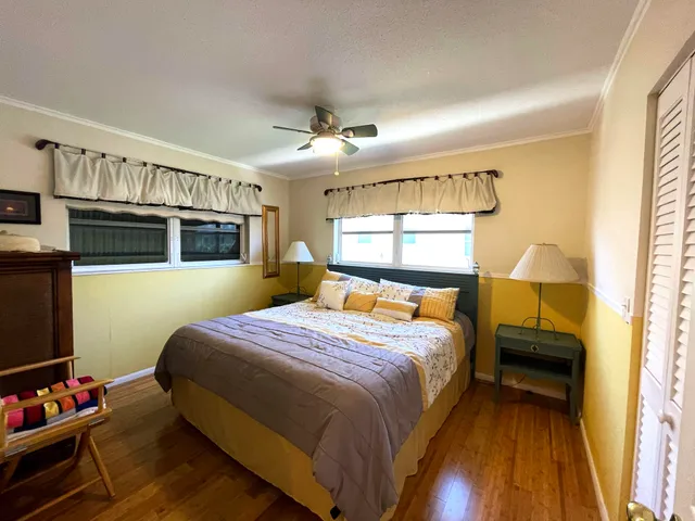 a bedroom with a bed wooden floor and window