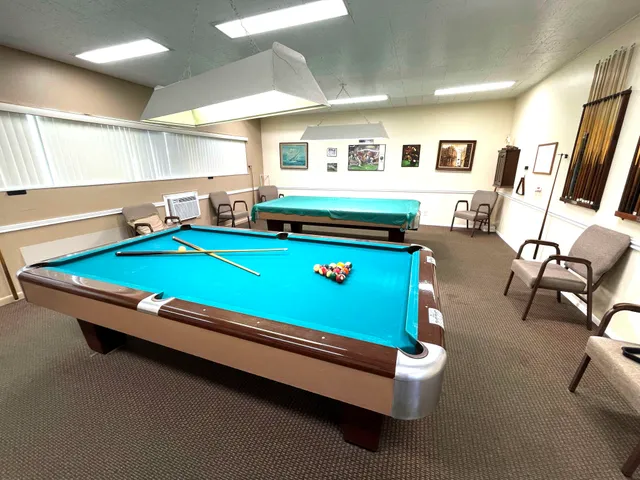 a room with pool table and windows