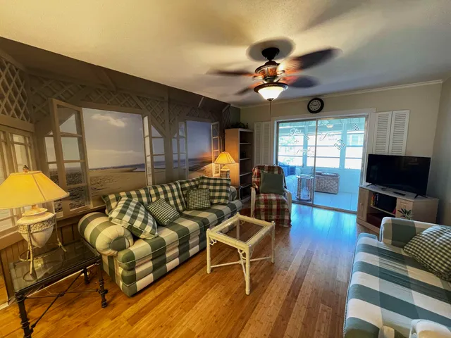 a living room with furniture a ceiling fan and a flat screen tv