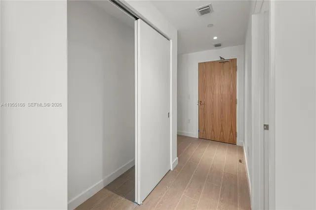 a view of hallway with wooden floor