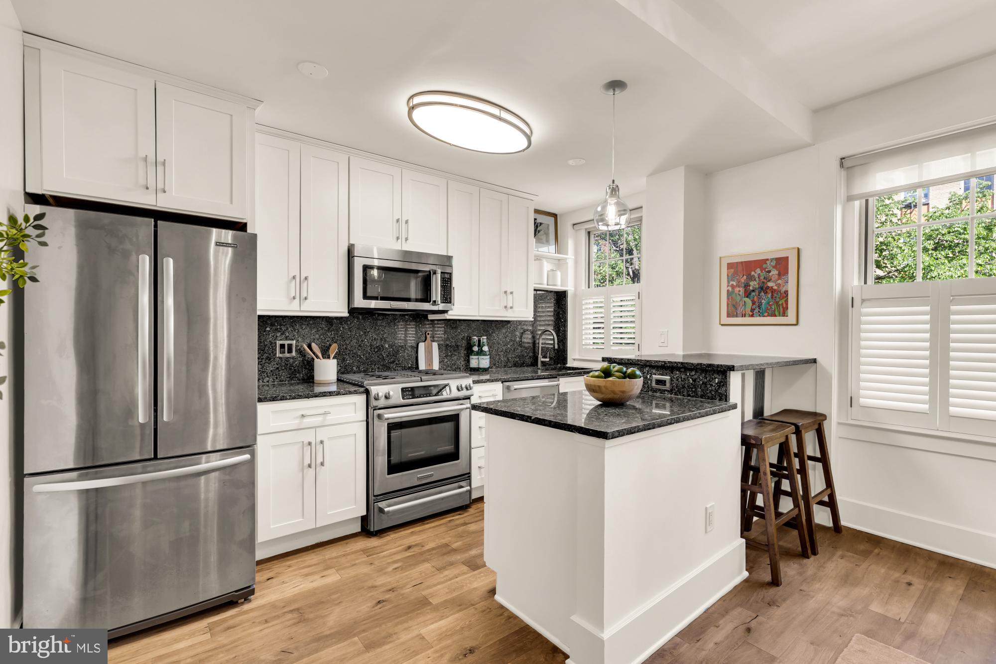1910 Kalorama Road Northwest, Unit 302 Washington, DC 20009 - Photo 9 of 28 a kitchen with stainless steel appliances granite countertop a stove a refrigerator a sink a stove and white cabinets with wooden floor