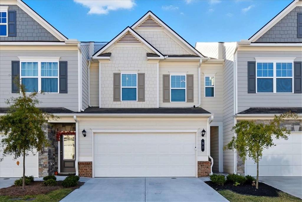 a front view of a house with a yard and potted plants