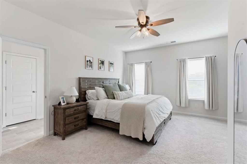 91 Pinnacle Way Jasper, GA 30143 - Photo 20 of 37 a spacious bedroom with a bed a ceiling fan and a dresser