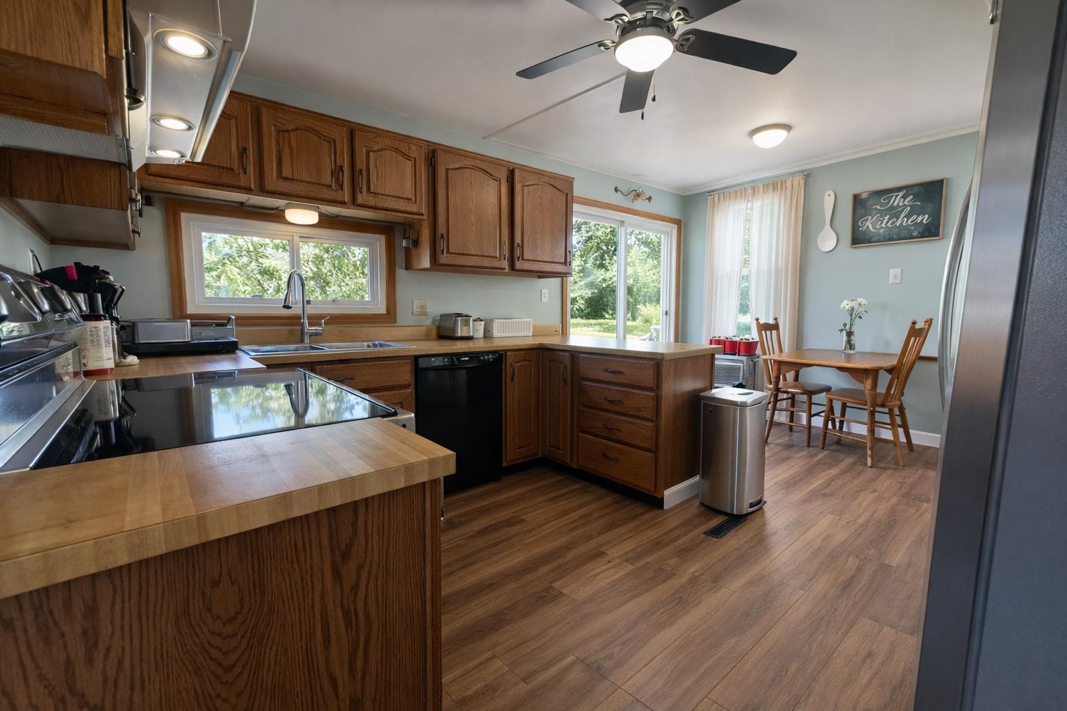 307 South 5th Street Oregon, IL 61061 - Photo 9 of 18 a kitchen with wooden cabinets a sink dishwasher a dining table and chairs with wooden floor