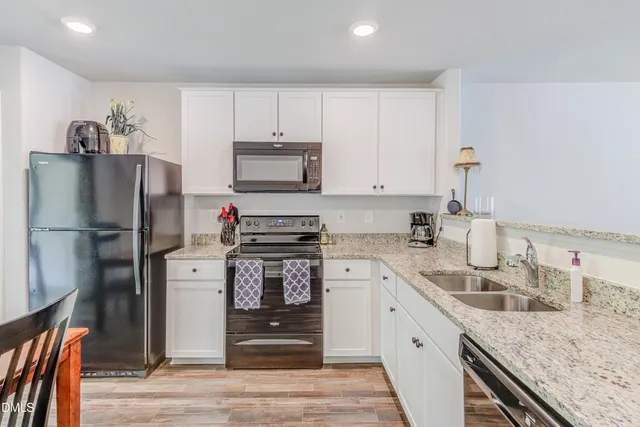 a kitchen with stainless steel appliances granite countertop a refrigerator stove and sink