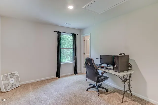 a view of a workspace with furniture and a window