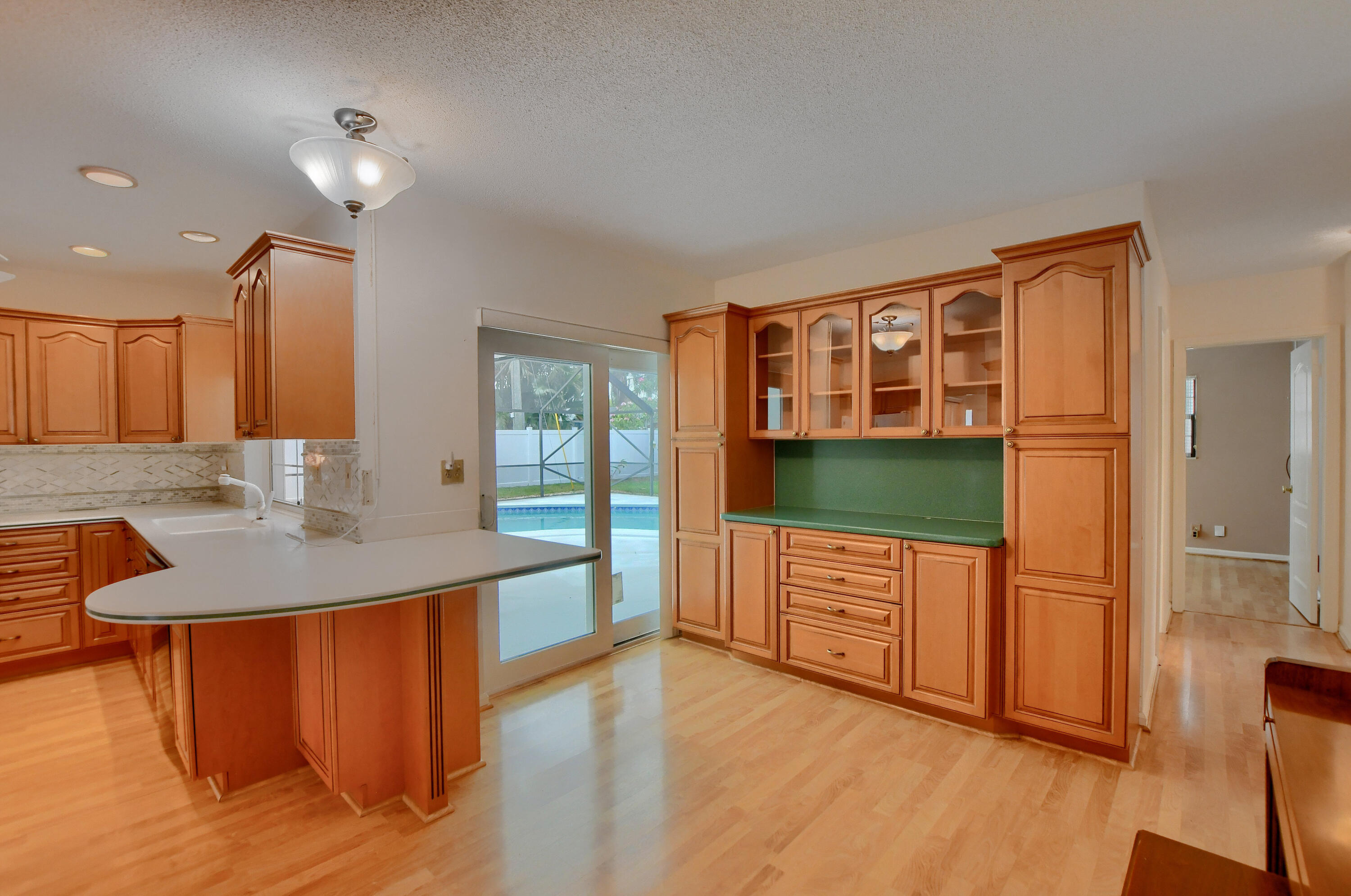 251 Southwest 9th Avenue Boca Raton, FL 33486 - Photo 14 of 37 a kitchen with stainless steel appliances granite countertop a sink a stove a refrigerator and white cabinets with wooden floor