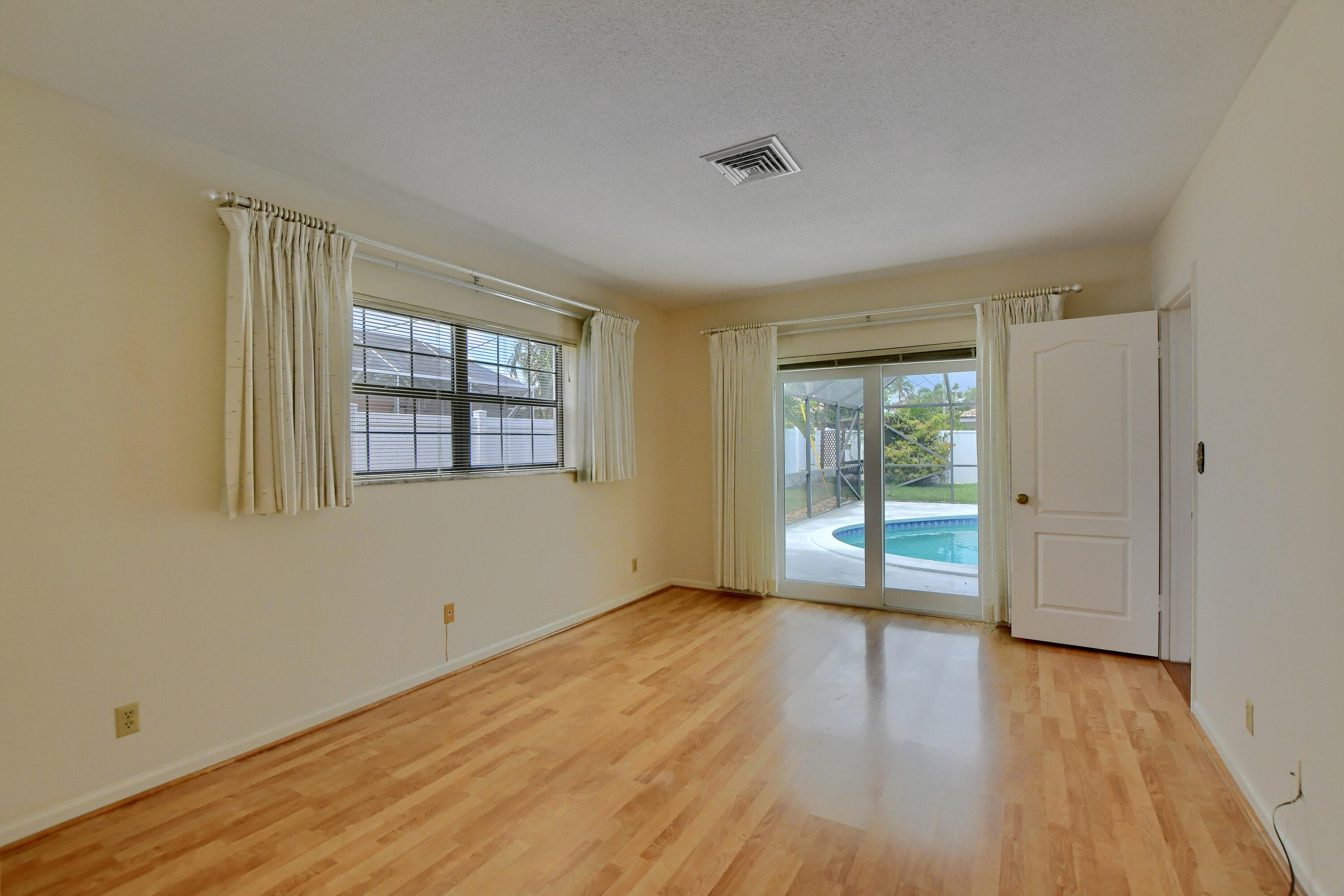 251 Southwest 9th Avenue Boca Raton, FL 33486 - Photo 16 of 37 a view of an empty room with wooden floor and a window