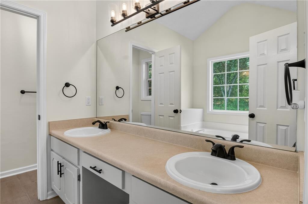 110 Chestnut Drive Covington, GA 30016 - Photo 17 of 27 a bathroom with a sink and a large mirror