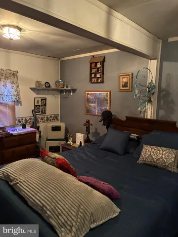 a bed sitting in a bedroom next to a window with pc on the table