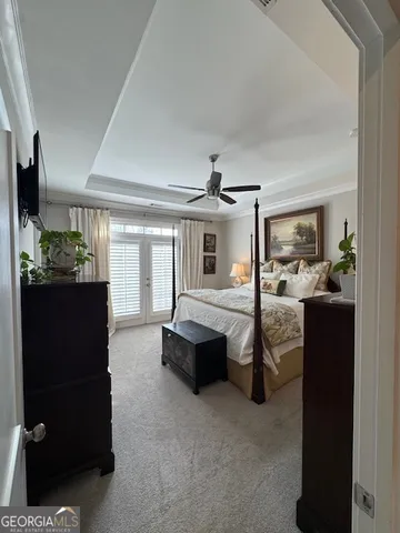 a spacious bedroom with a bed and a flat tv screen