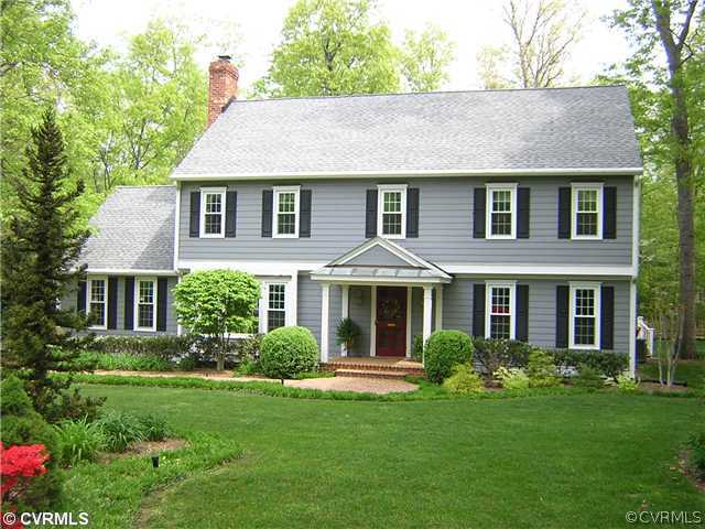 a front view of a house with a yard and trees