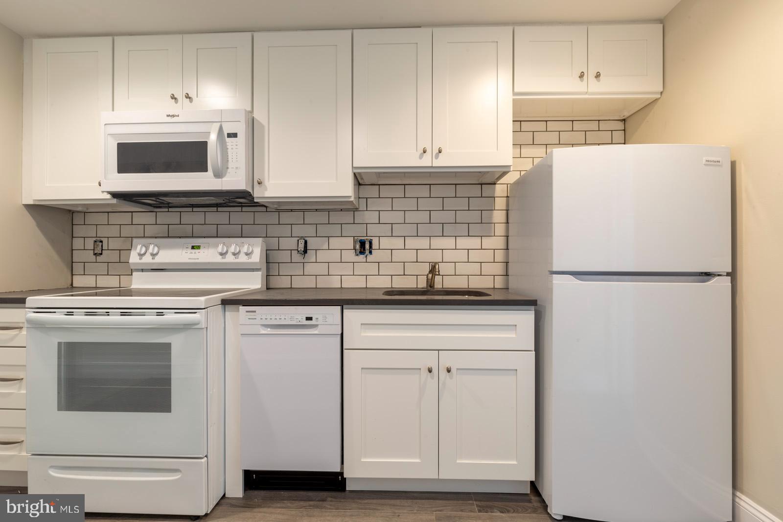 a kitchen with stainless steel appliances white cabinets and a sink