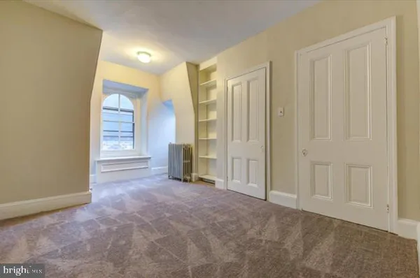 an empty room with windows and closet