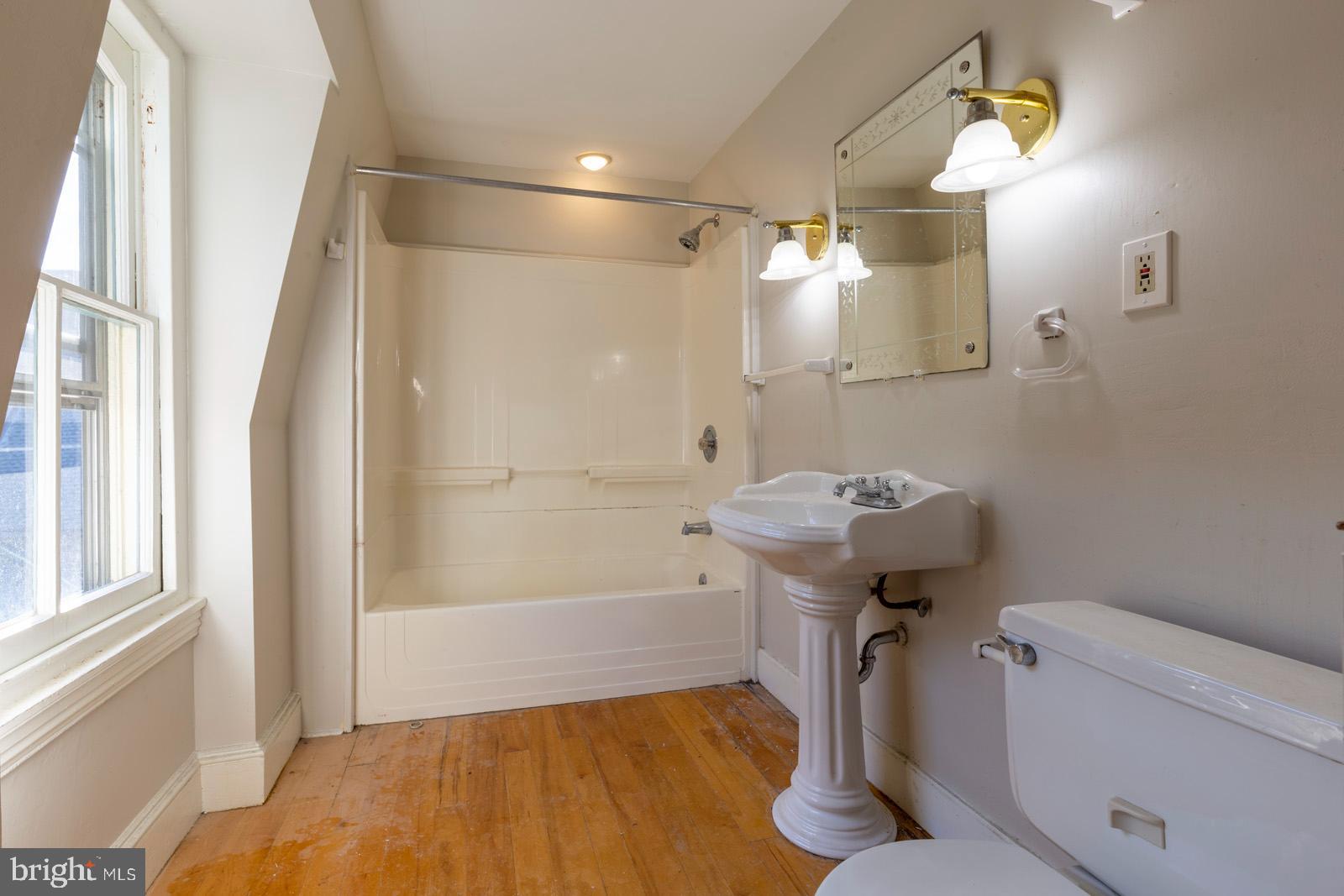 3604 Baring Street, Unit 2 Philadelphia, PA 19104 - Photo 7 of 22 a bathroom with a sink a toilet a mirror and shower