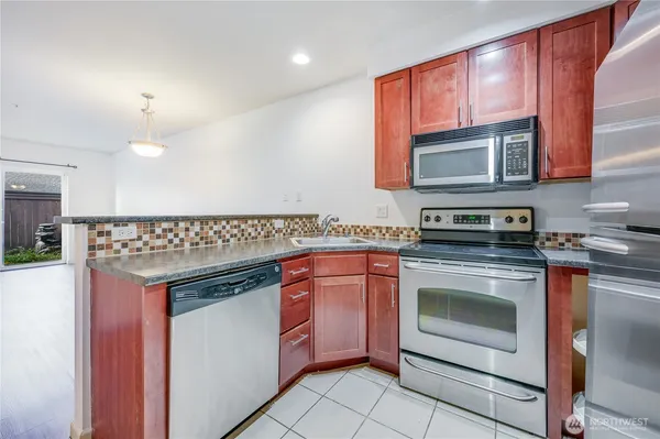 a kitchen with stainless steel appliances granite countertop a stove and a microwave