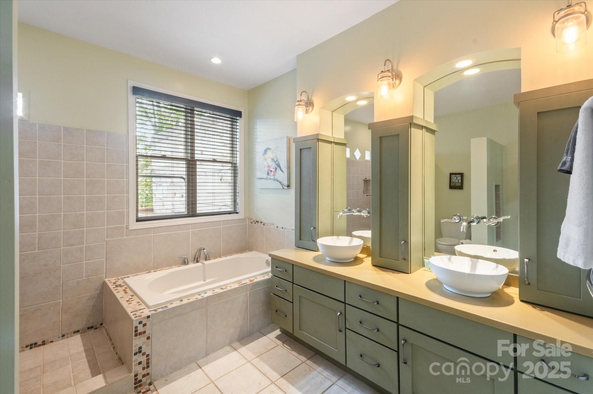 94 Davey Crockett Road Fairview, NC 28730 - Photo 15 of 41 a spacious bathroom with double vanity sinks a mirror and a bathtub