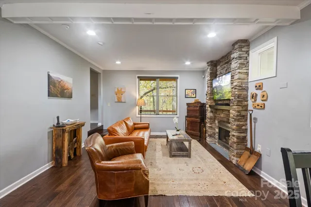 a living room with furniture a flat screen tv and a large window