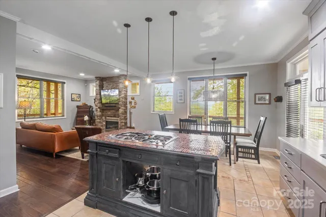 a dining hall with stainless steel appliances granite countertop a stove and a dining table chair