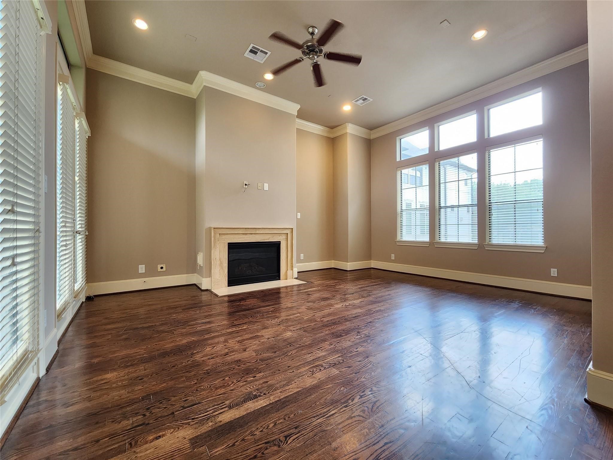 3205 Center Street Houston, TX 77007 - Photo 6 of 24 an empty room with wooden floor fireplace and windows