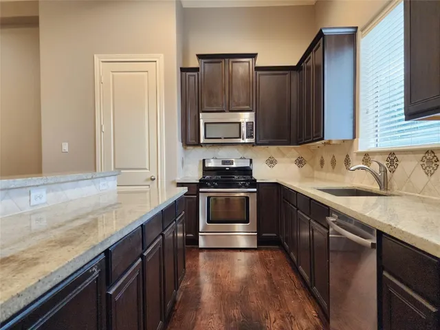 a kitchen with granite countertop a stove and a sink