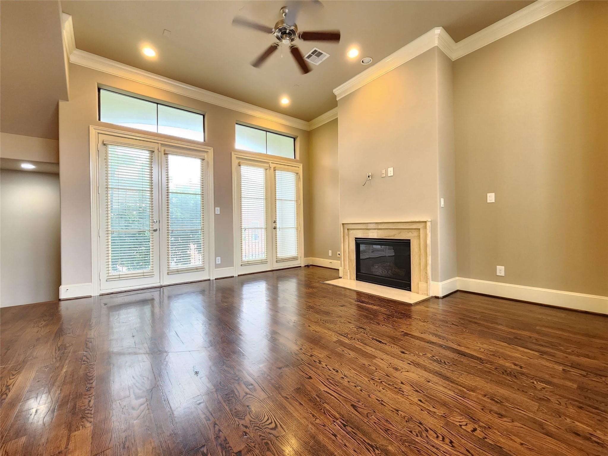 3205 Center Street Houston, TX 77007 - Photo 10 of 24 an empty room with wooden floor fireplace and windows