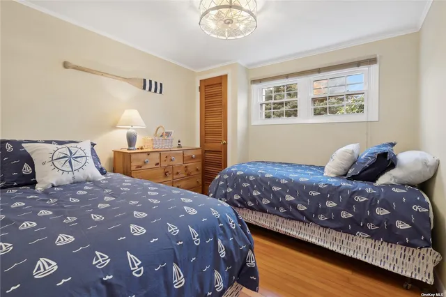 a bedroom with a large bed and a lamp on dresser