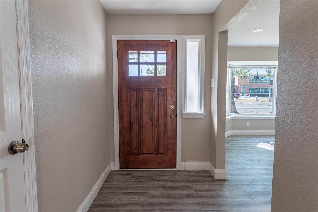 11005 Ferguson Road Dallas, TX 75228 - Photo 3 of 23 Wood-finish flooring, paneled entry door with glass inserts, transom window, and bay windows