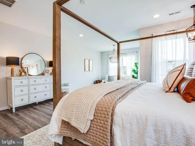 a bedroom with a bed a dresser and chair