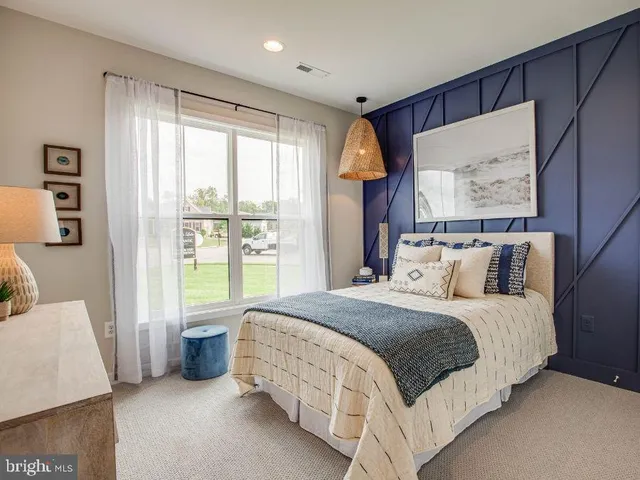 a large bed sitting in a bedroom next to a window