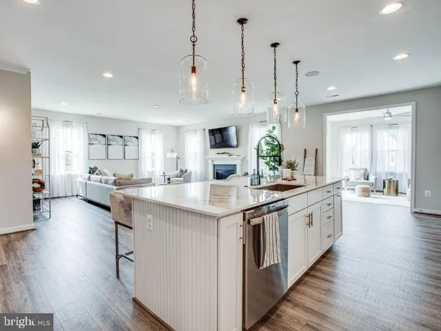 a kitchen with stainless steel appliances kitchen island a large island in the center and wooden floors