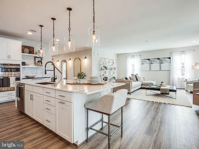 a large kitchen with kitchen island a island a sink a stove and wooden floor