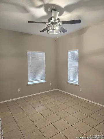 a view of a livingroom with a chandelier fan and windows
