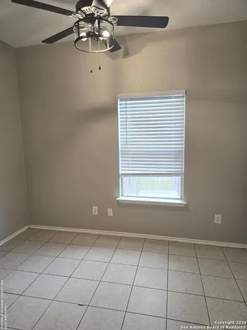 a view of a room with a chandelier fan and windows