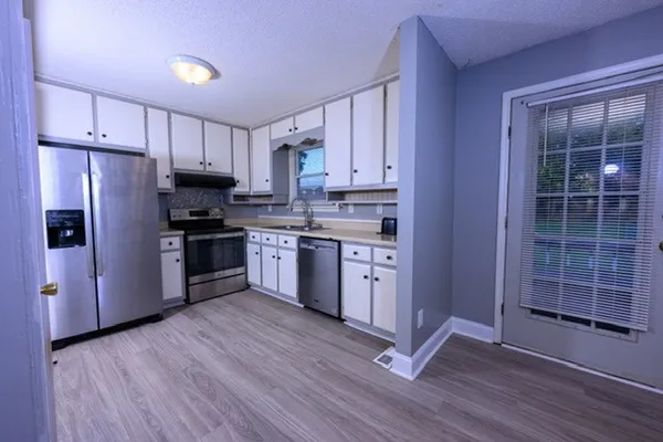a kitchen with stainless steel appliances granite countertop a stove a sink and a refrigerator