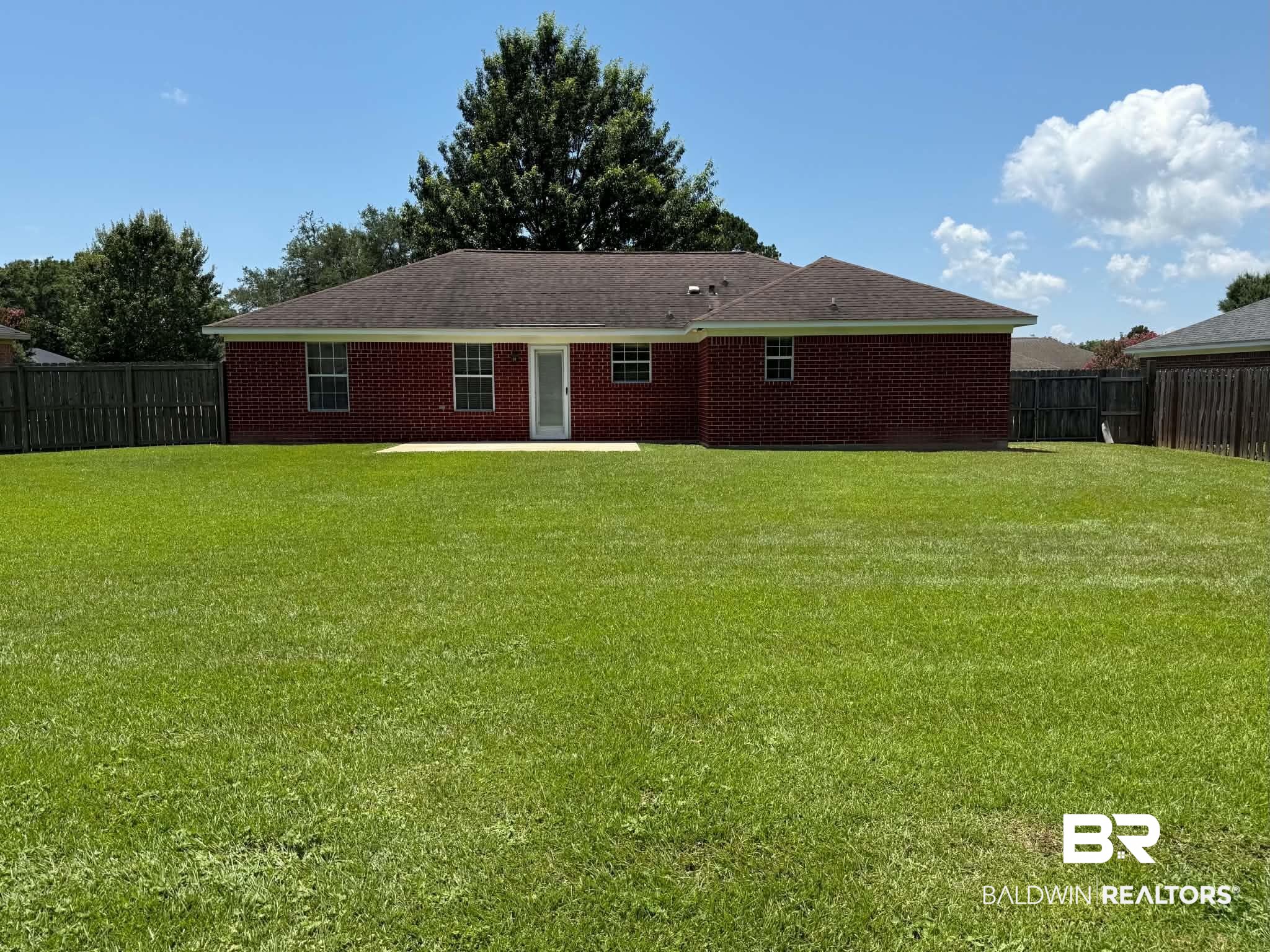 123 Pennbrooke Loop Foley, AL 36535 - Photo 8 of 49 Spacious backyard featuring an expansive lawn, full privacy fencing, and a brick exterior with a rear patio
