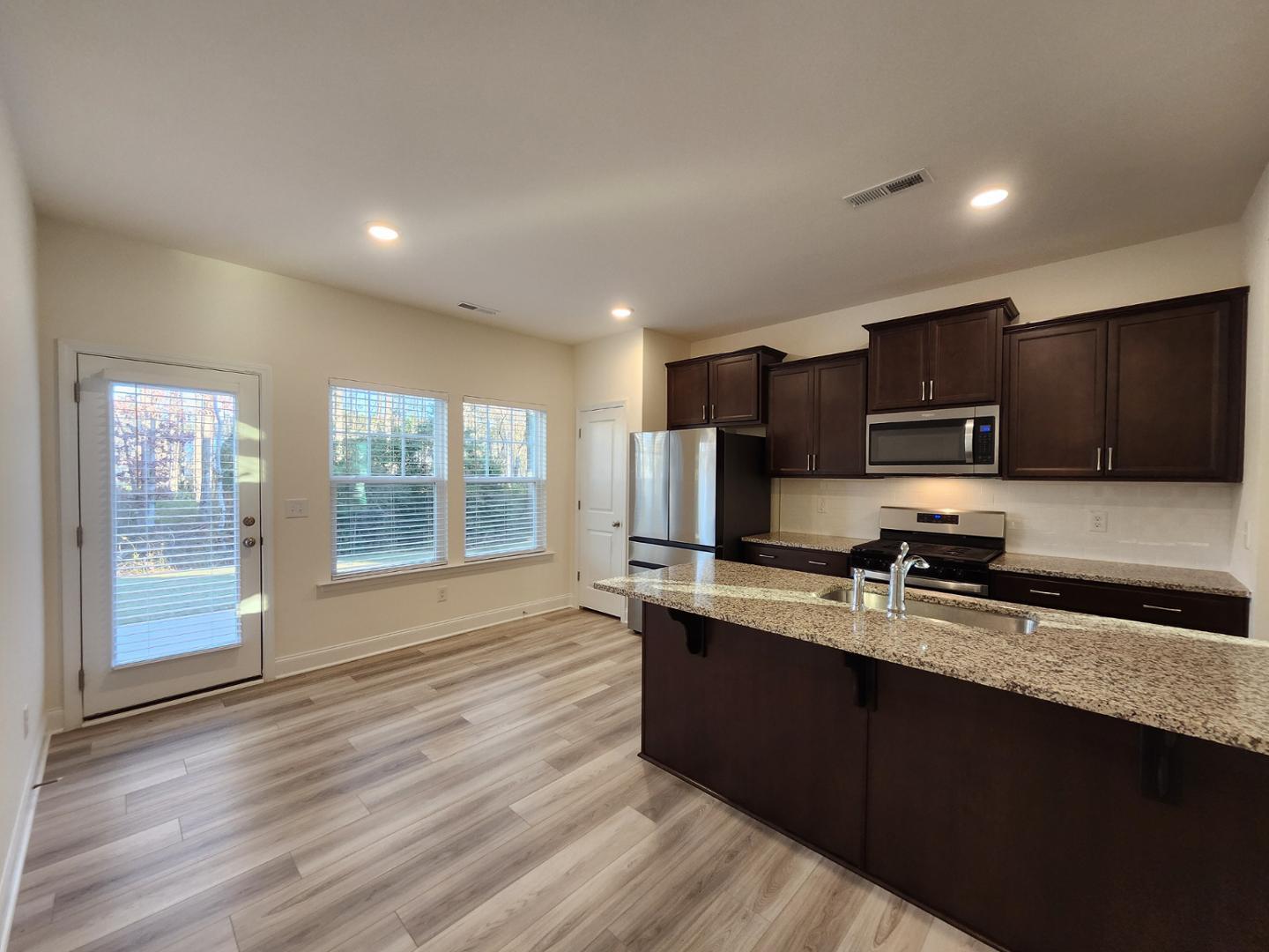 1224 Weavers Trce Drive Zebulon, NC 27597 - Photo 5 of 21 a kitchen with stainless steel appliances granite countertop a sink stove and microwave