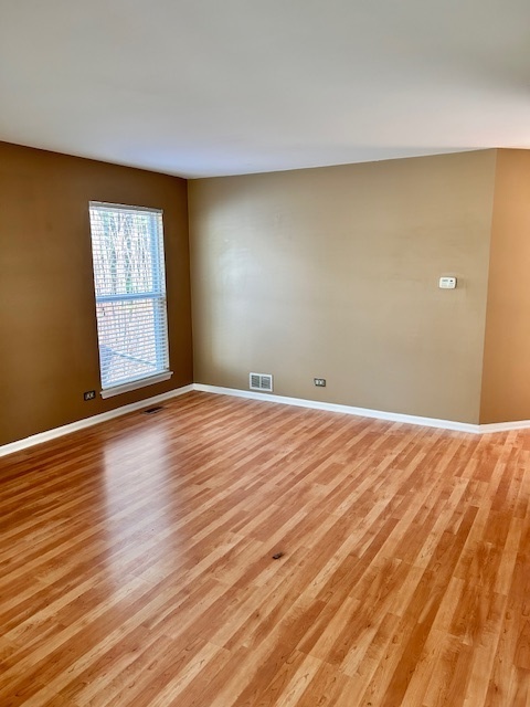 711 Violet Circle Naperville, IL 60540 - Photo 3 of 21 a view of an empty room with wooden floor and a window