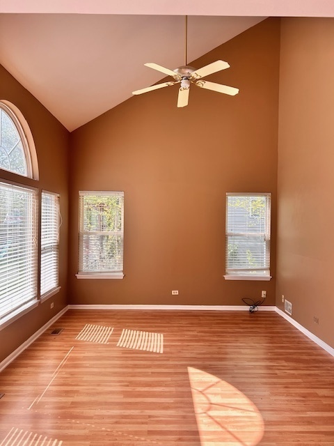 711 Violet Circle Naperville, IL 60540 - Photo 4 of 21 an empty room with wooden floor fan and windows