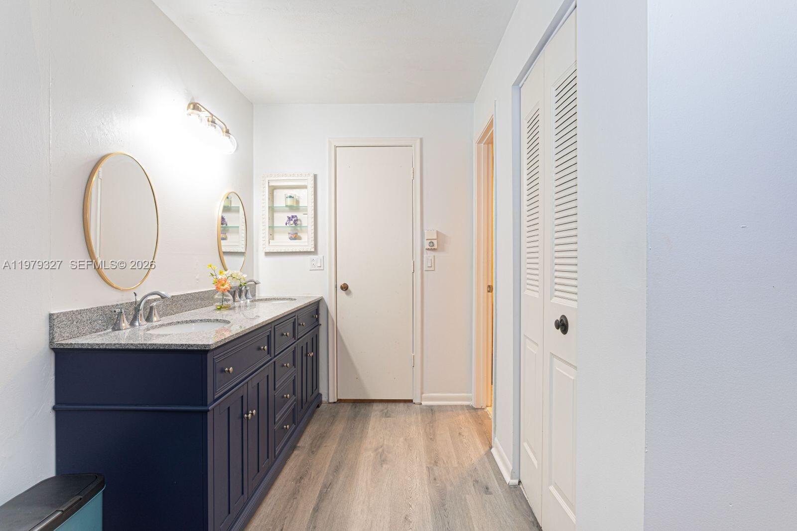 1421 Northwest 19th Terrace, Unit 102 Delray Beach, FL 33445 - Photo 13 of 30 a bathroom with a granite countertop sink a mirror and a shower