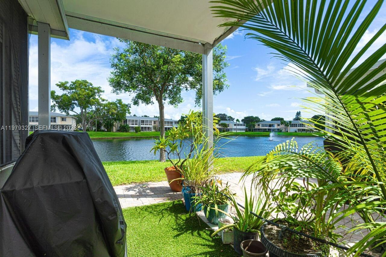 1421 Northwest 19th Terrace, Unit 102 Delray Beach, FL 33445 - Photo 21 of 30 a view of a lake with a floor to ceiling window next to a yard