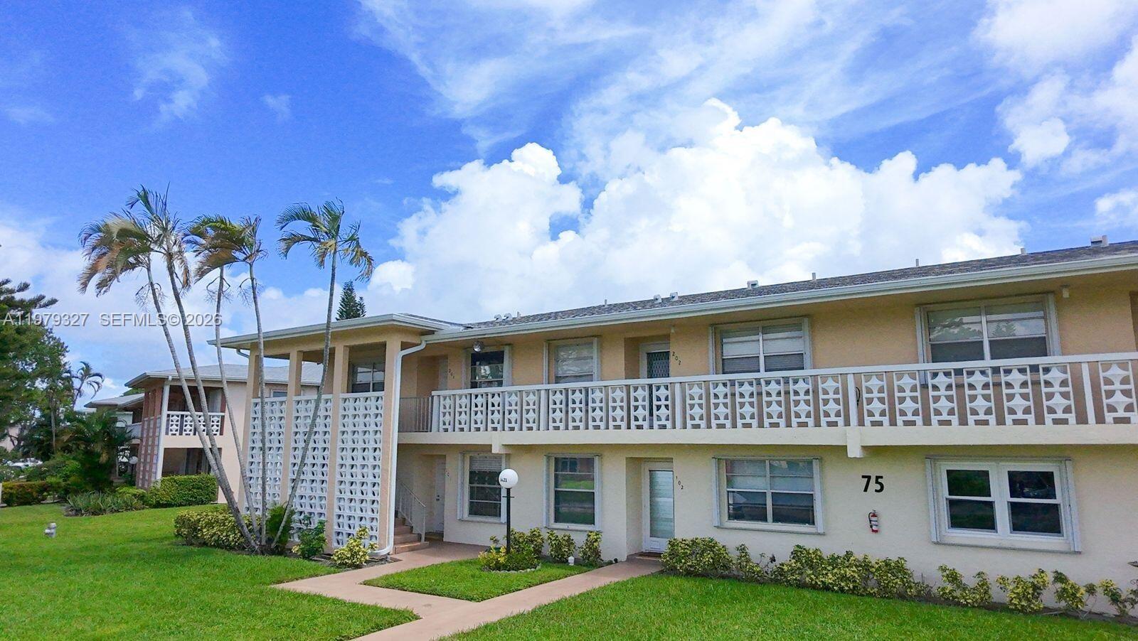 1421 Northwest 19th Terrace, Unit 102 Delray Beach, FL 33445 - Photo 26 of 30 a front view of a house with garden