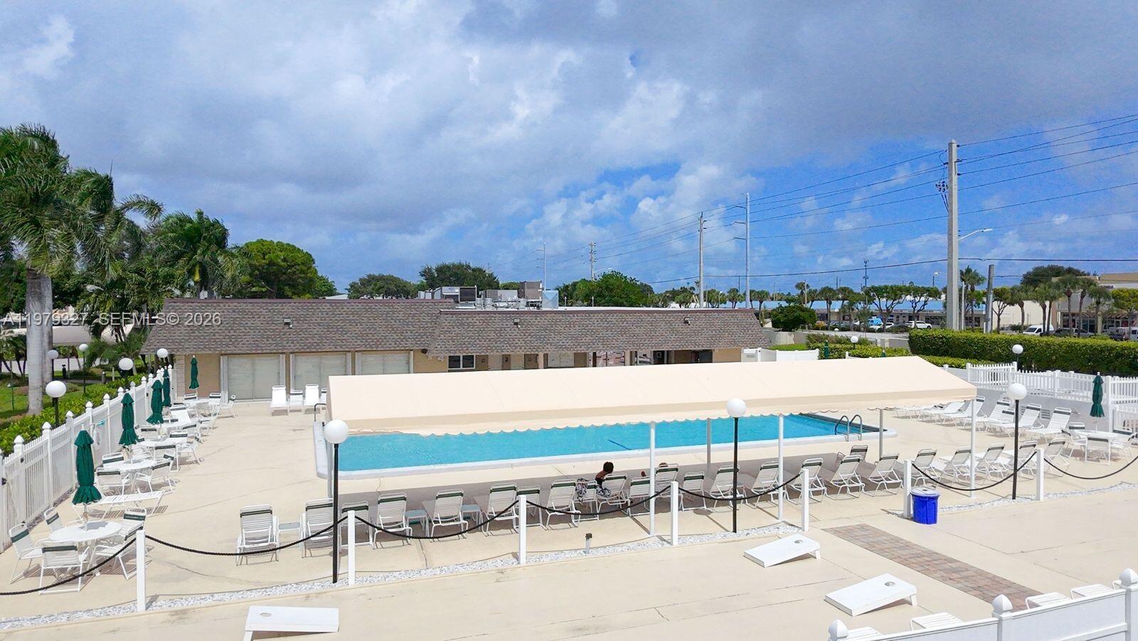 1421 Northwest 19th Terrace, Unit 102 Delray Beach, FL 33445 - Photo 29 of 30 a view of swimming pool with outdoor seating and city view